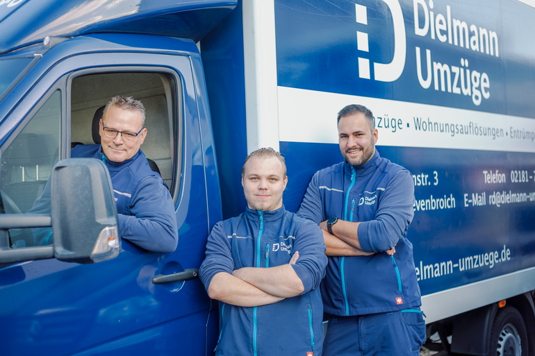 Das Bild zeigt zwei Mitarbeiter der Firma Dielmann-Umzüge beim Verladen eines Schranks in Mönchengladbach